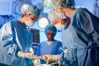 Surgeons conducting anorectal malformation surgery in a sterile operating room, focused on patient care and precision.