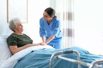 A nurse assists an elderly woman in bed, providing care and support post-bariatric surgery.