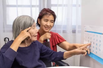 A senior woman smiling while solving a crossword puzzle, promoting brain fitness and cognitive health for seniors.