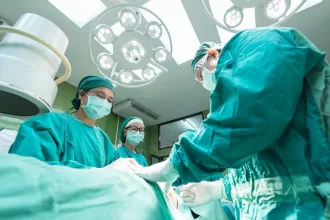 Surgeons skillfully performing burn reconstruction surgery in a sterile operating room, focused on patient care and recovery.