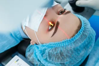 A woman in a blue gown undergoes an eye examination, preparing for cataract surgery.