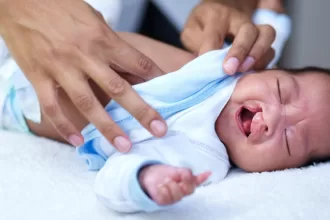 A caregiver gently holds a baby, showcasing a moment of tenderness following cleft lip and palate repair.