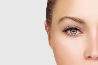 A close-up of a woman's face highlighting her green eye, symbolizing resilience after eye tumor surgery.