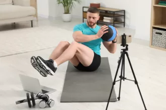 A fitness coach demonstrating exercises in a modern gym, combining strength training and cardio workouts, representing a hybrid workout program for a balanced fitness routine.