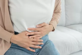 A woman gently resting her hands on her stomach, reflecting on her recent hysterectomy experience.