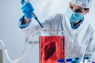 An extreme close-up of lab-grown meat, laid out on a white plate with an overhead view of a lab background.