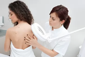 A woman receiving a therapeutic back massage from a doctor, focusing on relief after skin tumor excision.