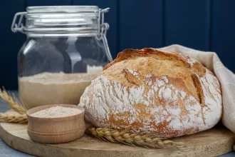 Freshly baked sourdough bread on a wooden board, showcasing its golden crust and airy texture, with health benefits linked to gut health.