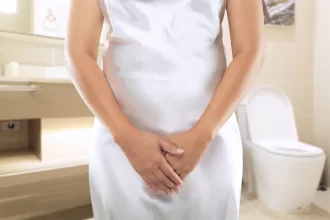 A woman in a white dress stands in a bathroom, symbolizing confidence and renewal after vaginal rejuvenation surgery.