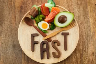 A healthy meal plate with colorful vegetables, lean protein, and a clock, symbolizing the concept of intermittent fasting for better health.