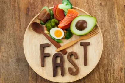 A healthy meal plate with colorful vegetables, lean protein, and a clock, symbolizing the concept of intermittent fasting for better health.
