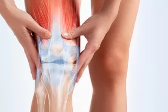 Knee replacement surgery procedure with a patient and surgical team in an operating room.